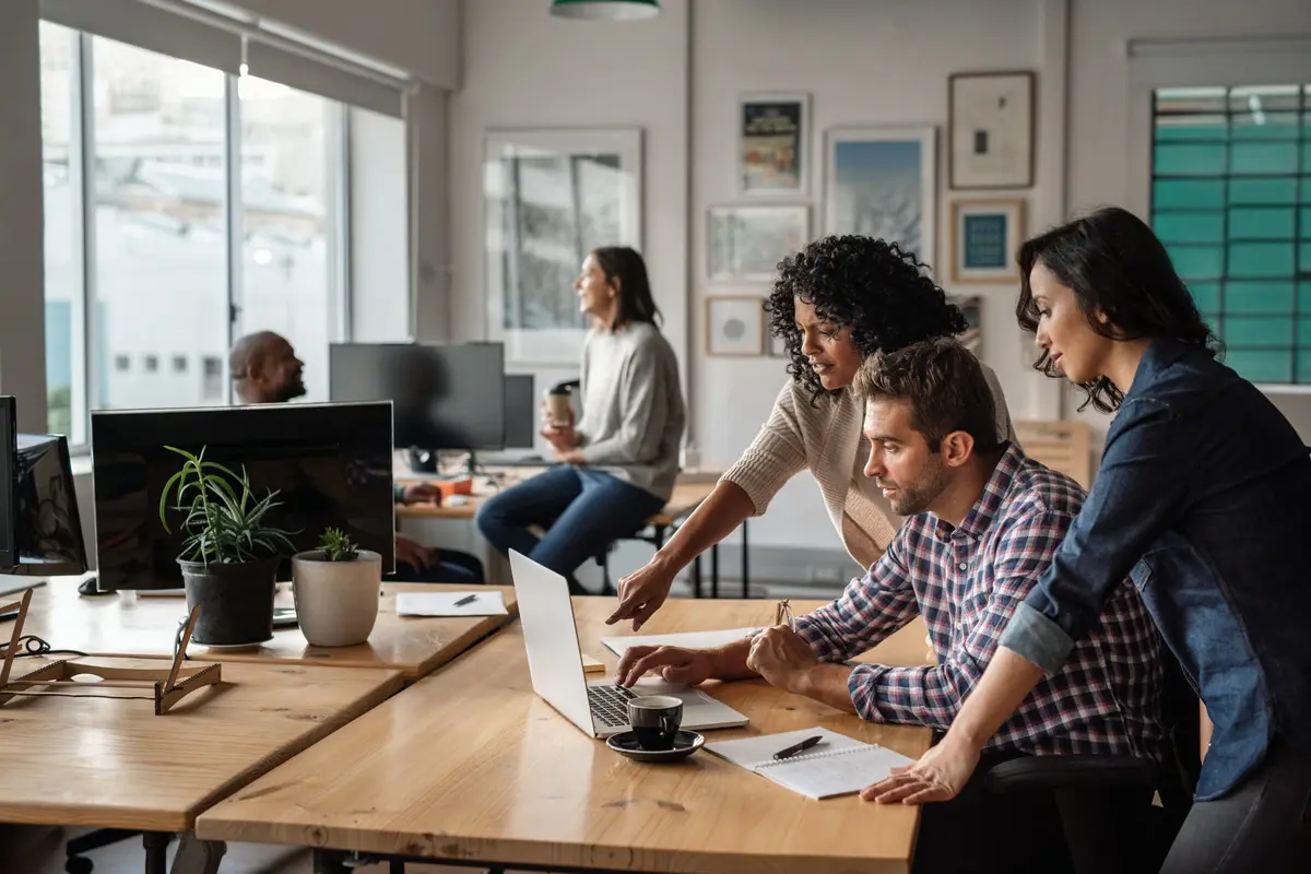 Réunion de travail autour d'une table, dans les bureaux de l'agence